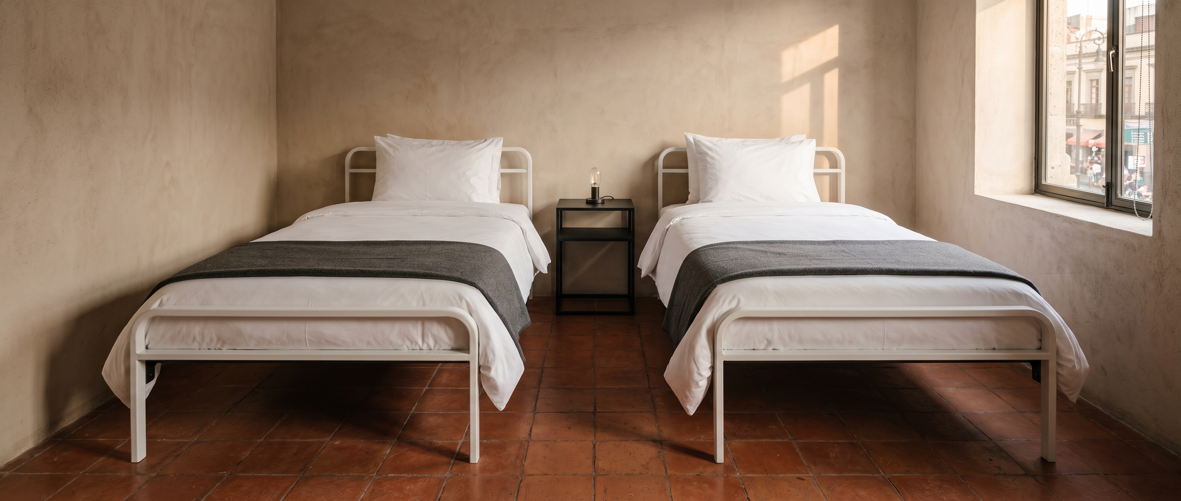Habitación doble de hotel con dos camas Basic de acero blanco fabricadas por Casa Ferro en CDMX