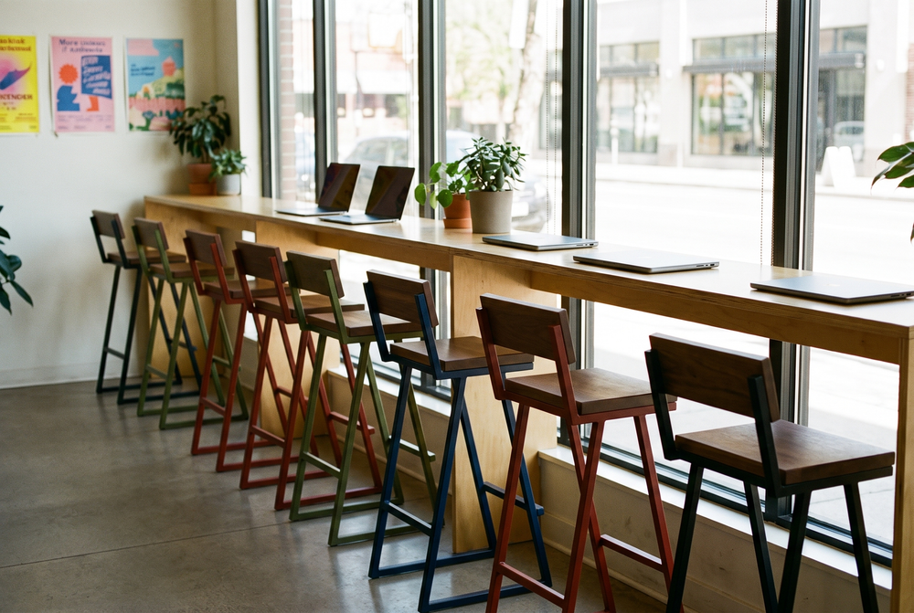 Barra larga de ventana en un coworking con bancos en cuatro colores
