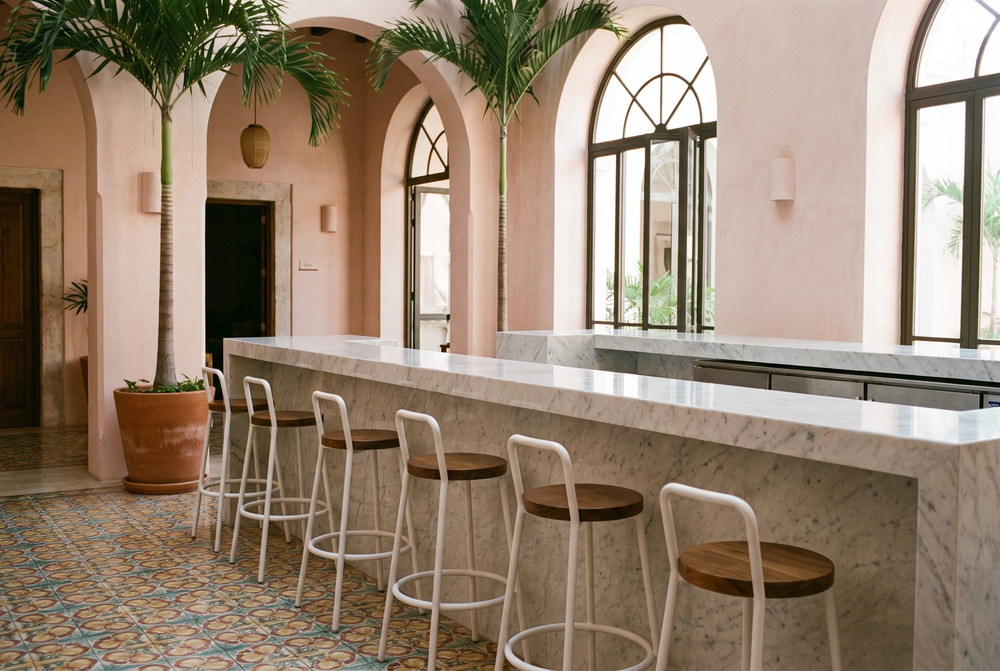 Barra de mármol en el lobby de un hotel con bancos blancos