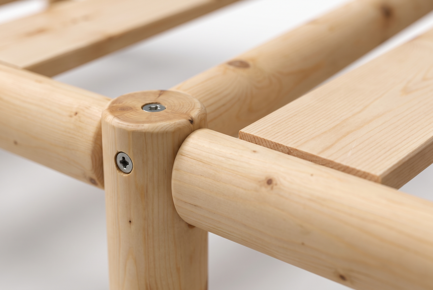 Detalle de la unión de la cama de madera Nara: tornillos a la vista en el poste torneado y listón con el corte de sierra a escuadra