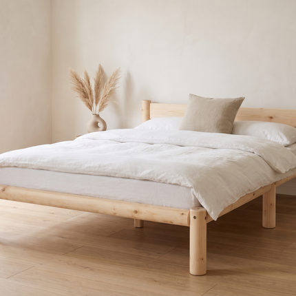 Cama de madera Nara en acabado Natural vestida con ropa de cama blanca