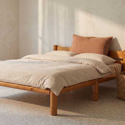 Cama de madera Nara en acabado Olmo en una recámara con luz de tarde