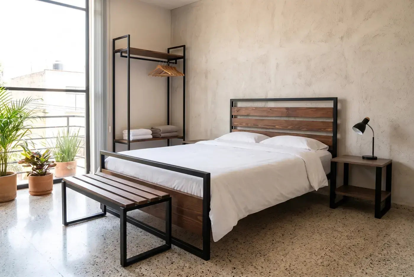 Habitación de hotel con cama de acero y nogal, burós y clóset abierto Casa Ferro