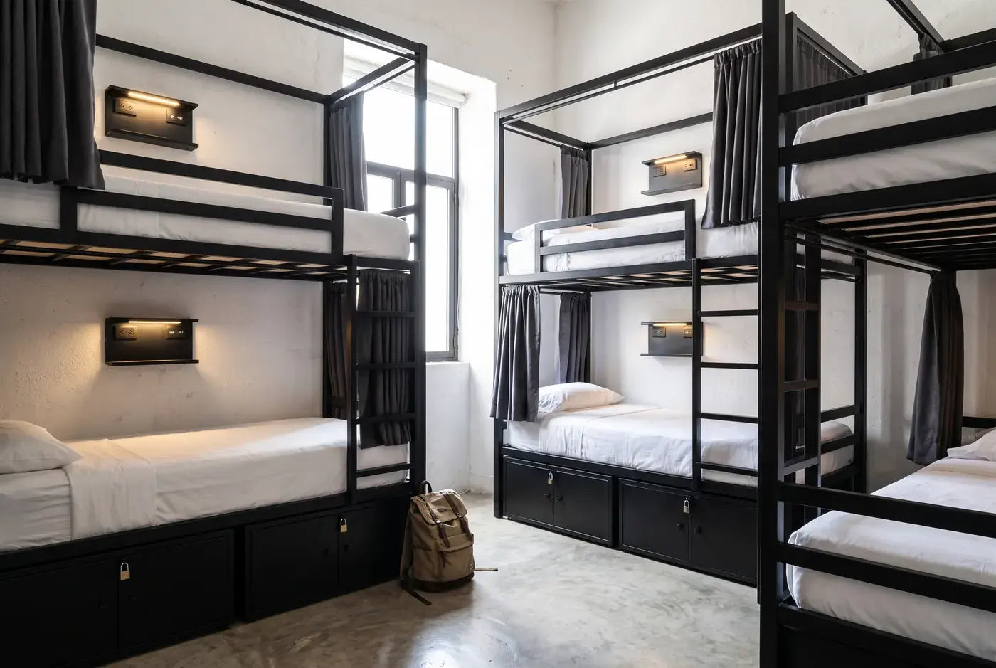 Dormitorio compartido de hostal con literas de acero y lockers