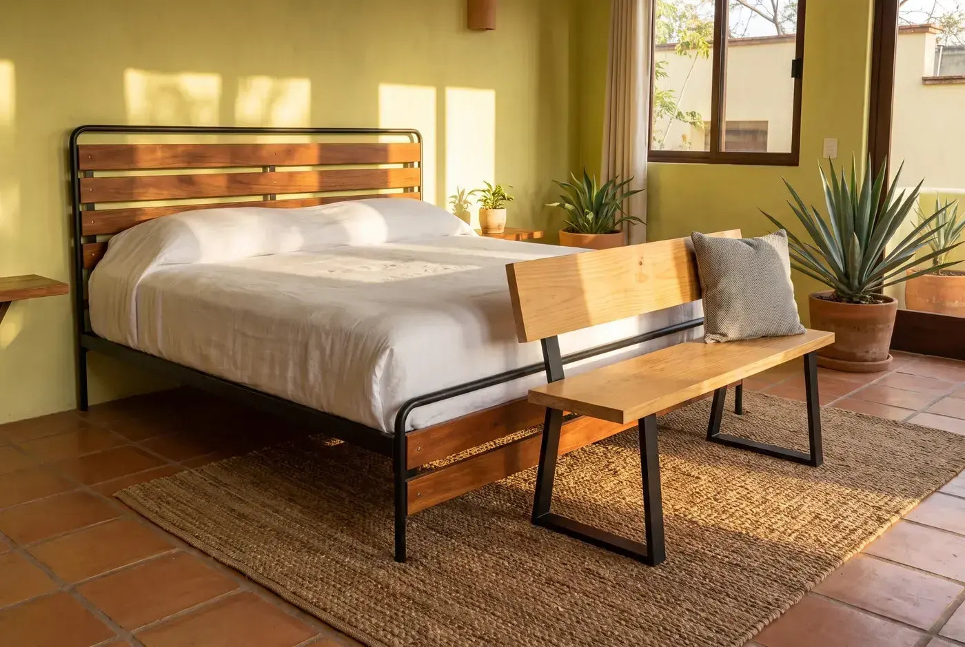 Suite de hotel boutique con cama de cumarú y banca pie de cama
