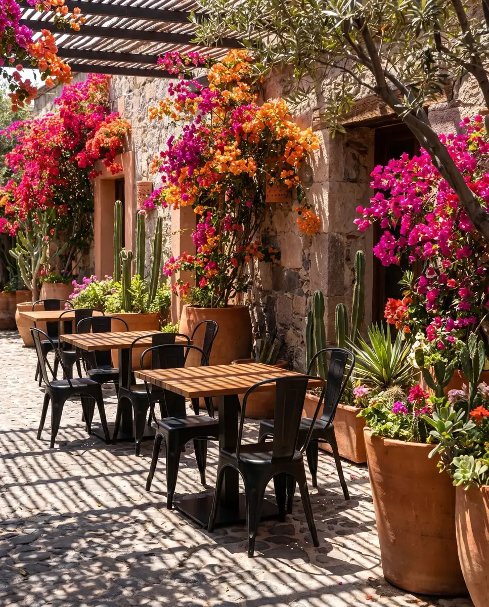 Patio de restaurante con mesas de cumarú de listones y sillas Tolix Casa Ferro