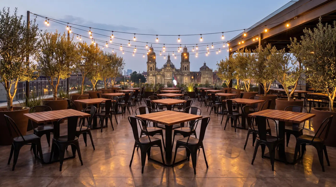 Terraza de restaurante con mesas de cumarú y sillas Tolix
